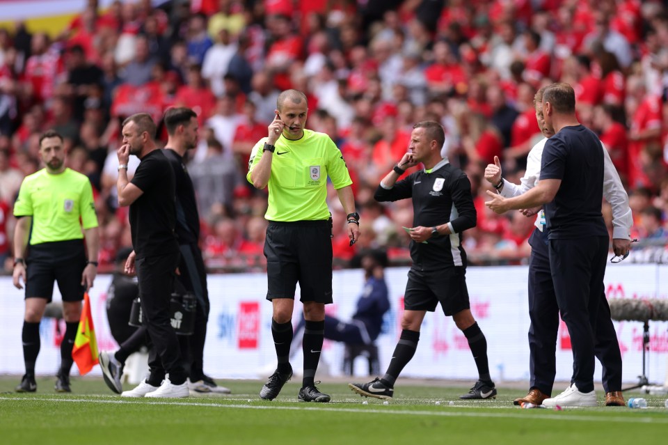 Referee adjusting his microphone during a soccer match.