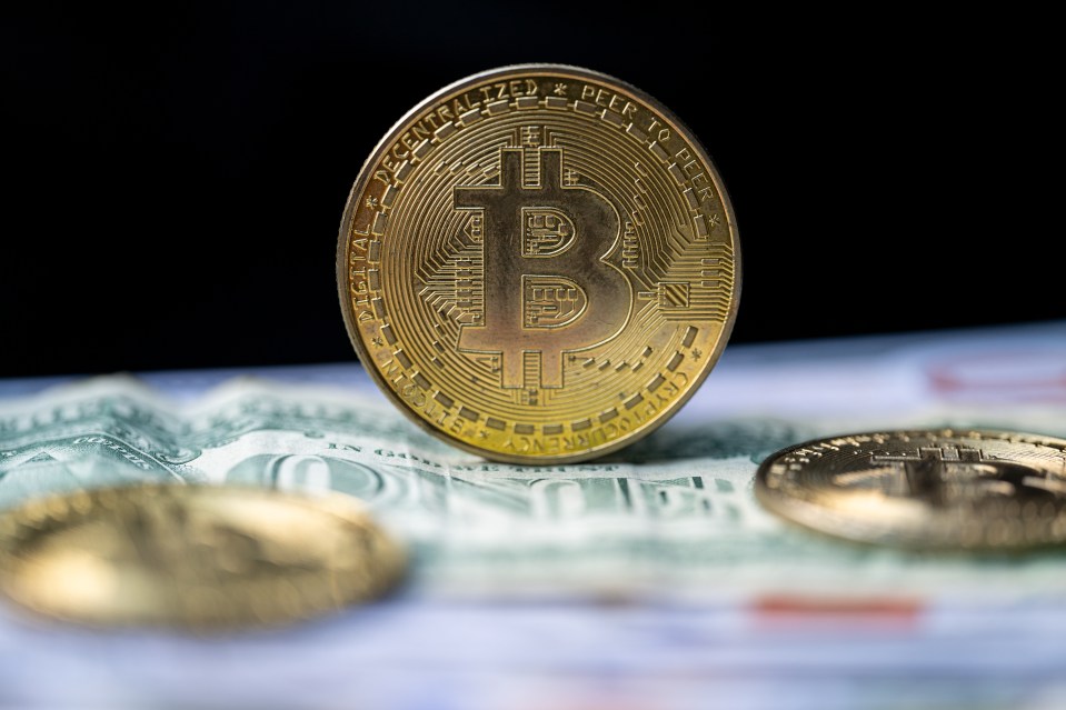 Bitcoin cryptocurrency on US dollar bills.