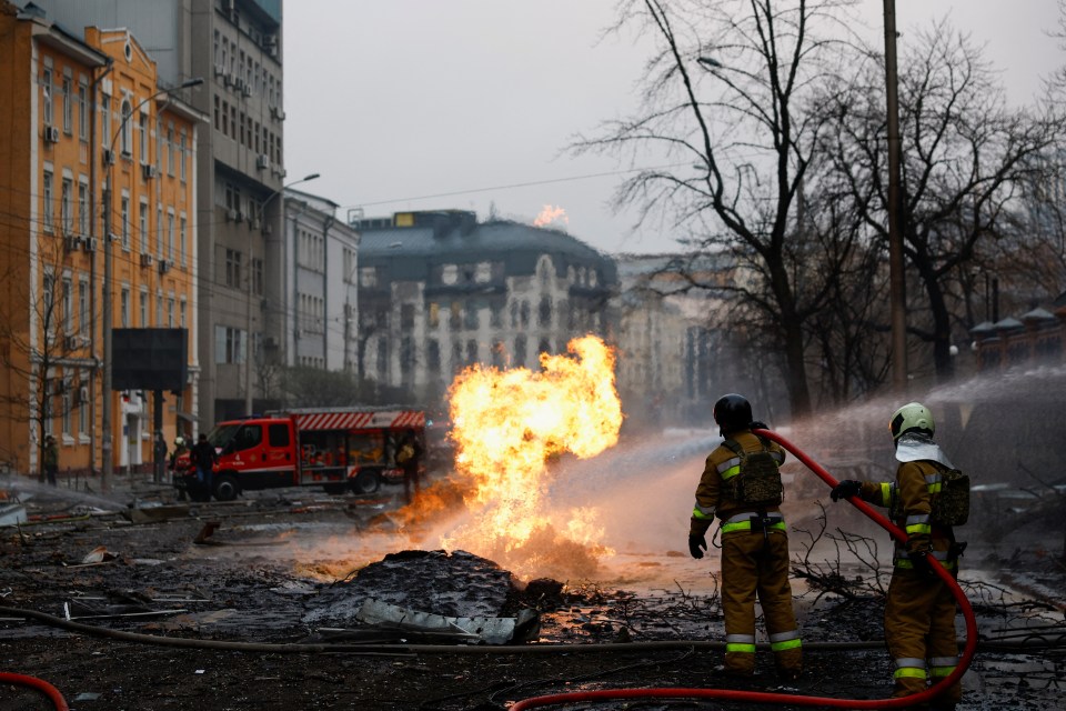 Firefighters battling a large fire at a destroyed building.