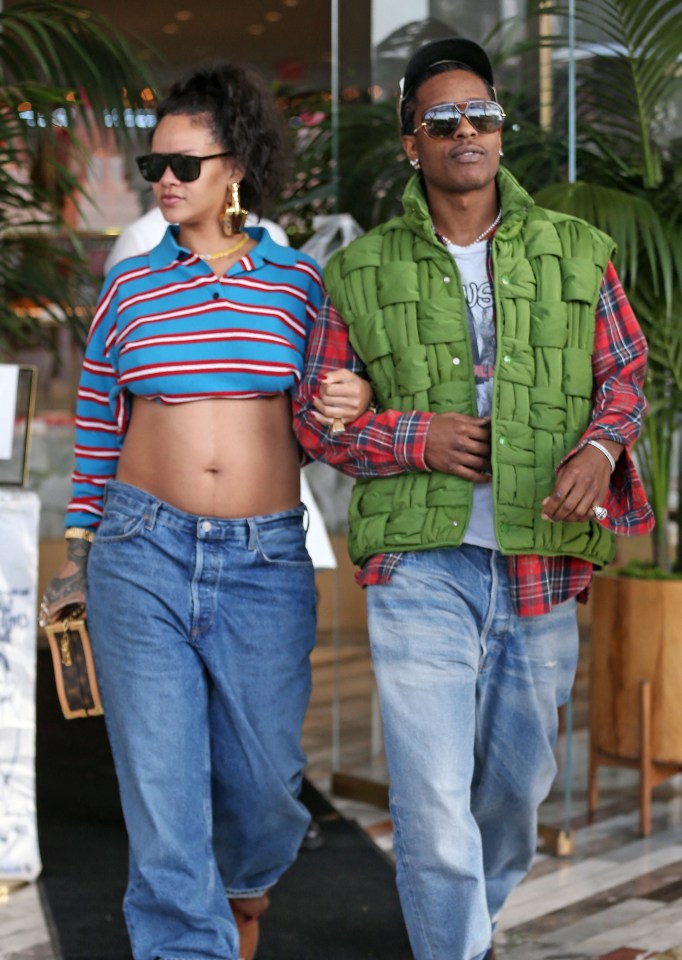 Rihanna and A$AP Rocky holding hands and leaving a restaurant.