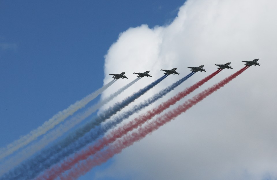 Jet planes flying in formation, leaving colored smoke trails.