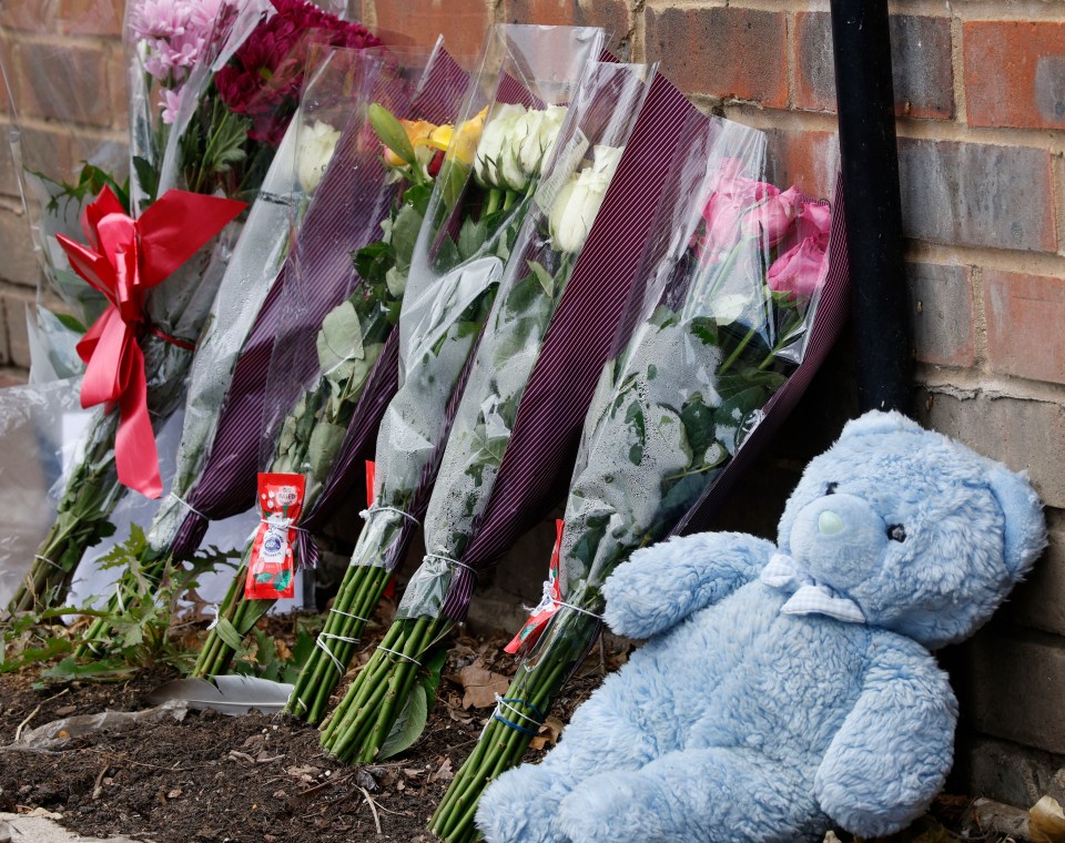 Flowers and a teddy bear left at the scene of a house fire.