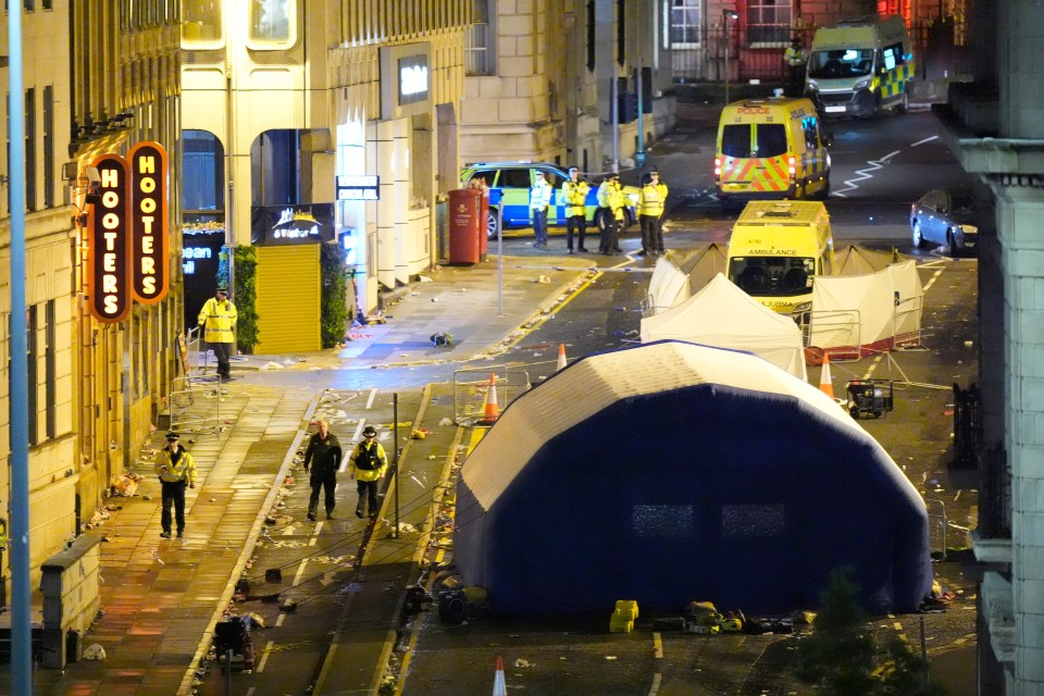 Aftermath of a car plowing into a crowd in Liverpool, showing police, emergency vehicles, and a temporary shelter.