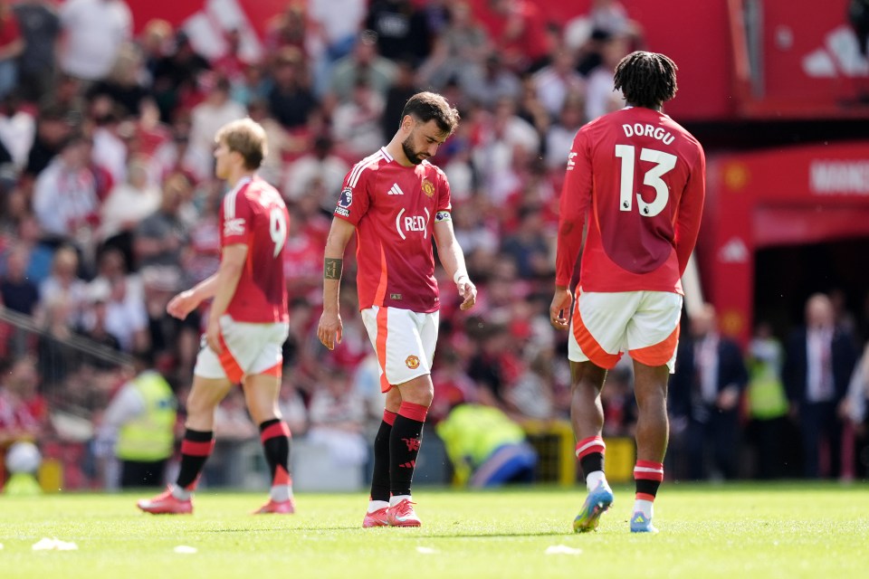 Manchester United players looking dejected on the field.