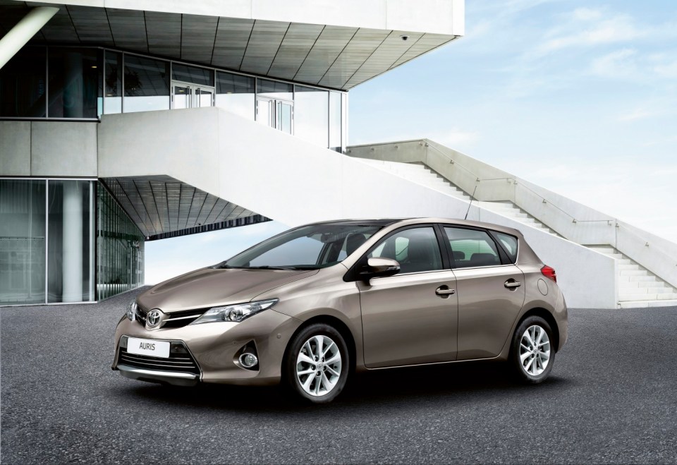 Toyota Auris parked in front of a modern building.