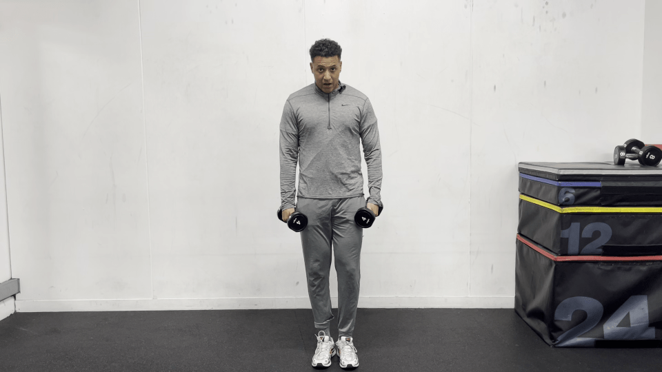 Man performing a dumbbell shoulder exercise.