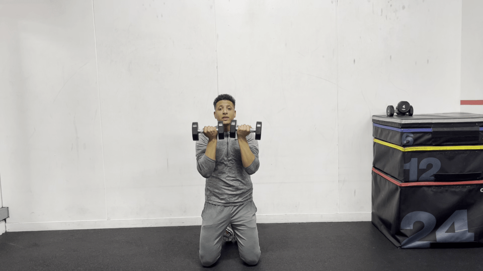 Man performing a dumbbell shoulder press.