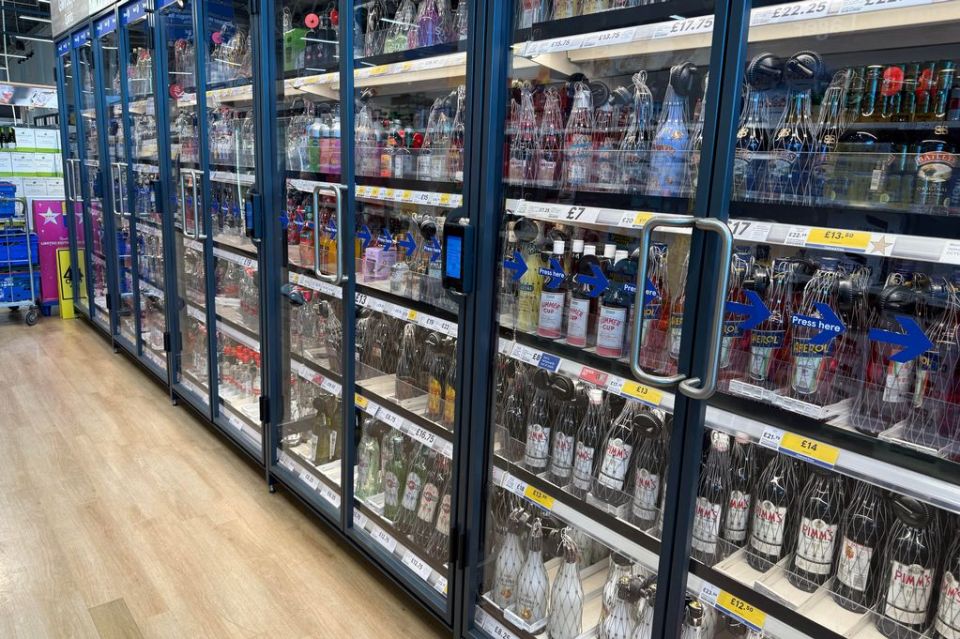 Alcohol in a supermarket secured behind glass doors.