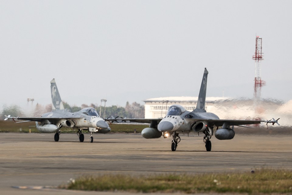 Two Taiwanese air force fighter jets taxiing on a runway.