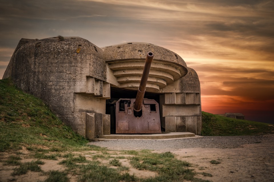 World War II gun turret in a coastal bunker at sunset.
