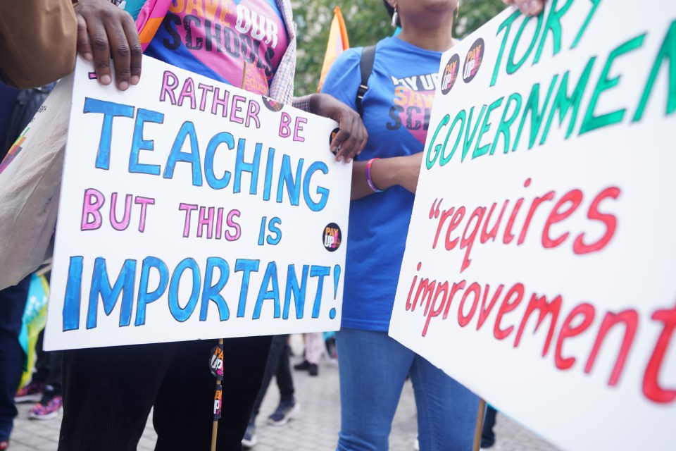 Protestors holding signs about teacher pay and the Tory government.