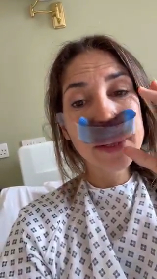 Woman in hospital gown with nasal dressing.