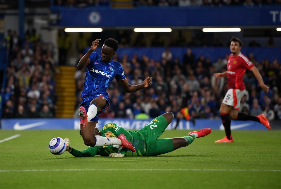 Chelsea's Tyrique George challenges Manchester United's Andre Onana for the ball.