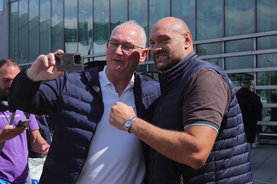 Tyson Fury and his father taking a selfie at an airport.