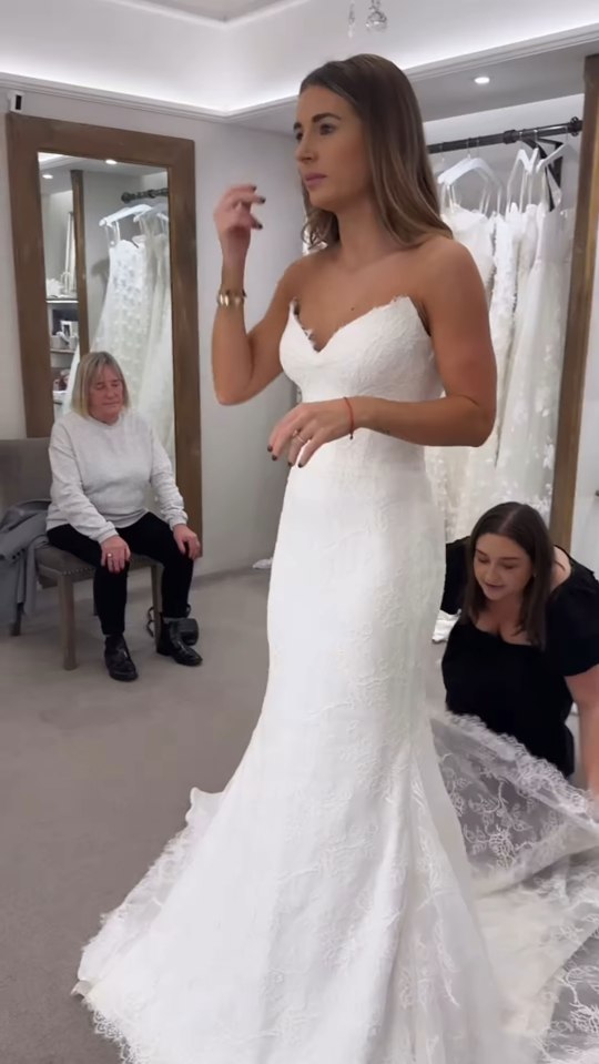 Woman trying on a wedding dress in a bridal shop.