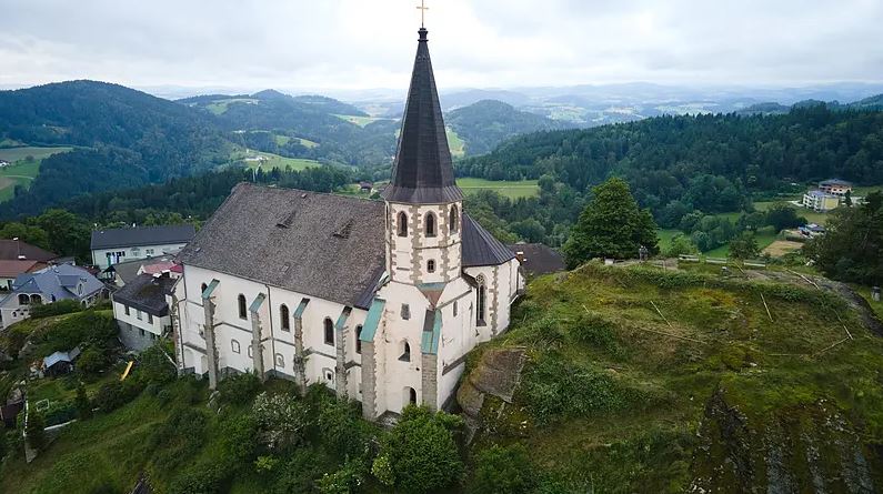 Aerial view of a church on a hilltop overlooking a valley.