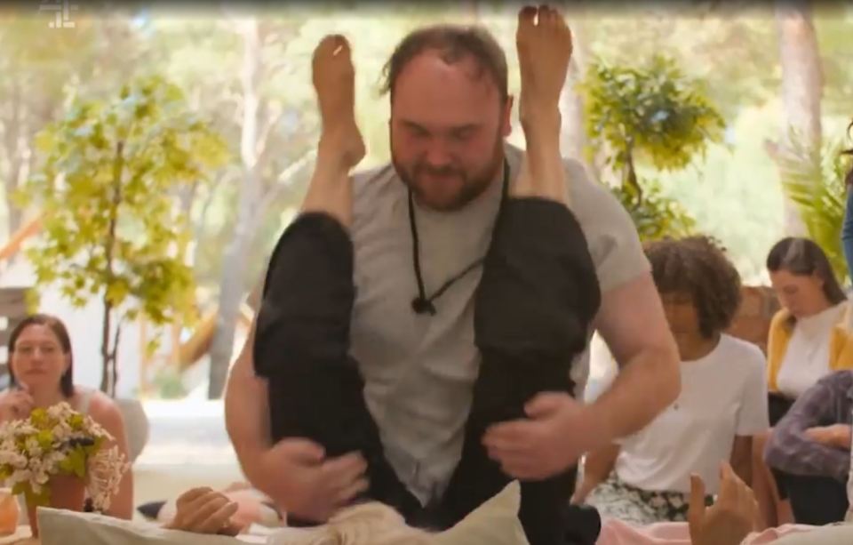 Man assisting woman with a leg stretch.