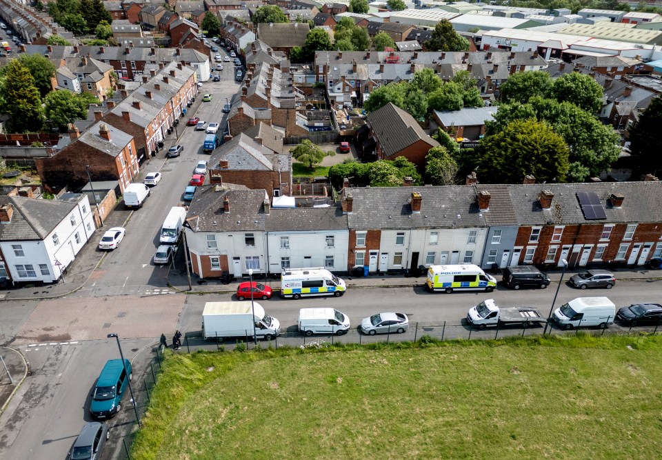 Aerial view of a residential street with police vehicles at a murder investigation site.