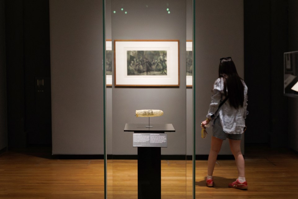 Museum exhibit featuring a 19th-century condom with an erotic illustration.