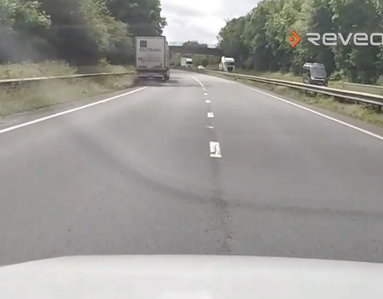 Dashcam footage of a truck swerving on a highway.