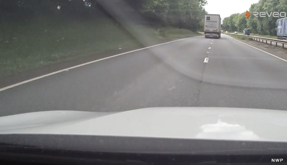 Dashcam footage of a truck swerving on a highway.