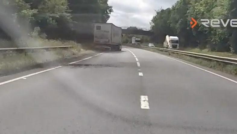 Dashcam footage of a truck swerving on a road.