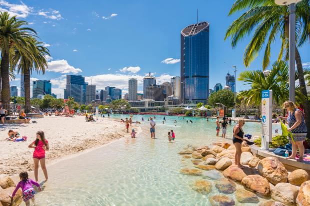 Streets Beach in Brisbane with city skyscrapers in the background.