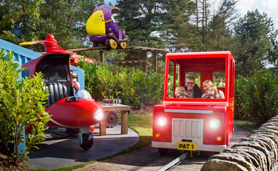 Family riding in a red Postman Pat-themed ride at Alton Towers.