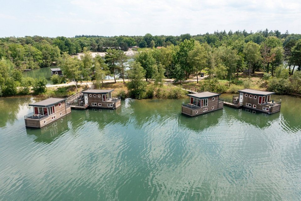 Aerial view of four houseboats on a lake.